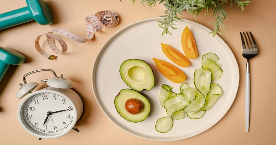 Composição Criativa Em Flat Lay Com Prato, Despertador, Faca, Garfo, Haltere Efita Métrica Sobre Fundo Rosa. Fasting Intermitente, Cetogênica, Conceito Dedieta. Vista De Cima, Espaço Para Texto/ Shutterstock - Foto Colaborador Goskovatatiana